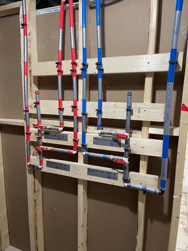 Labeled hot and cold waterline rough-in for a basement